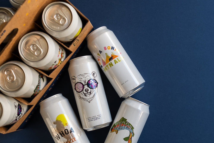 Assorted beer cans with unique designs on a blue background